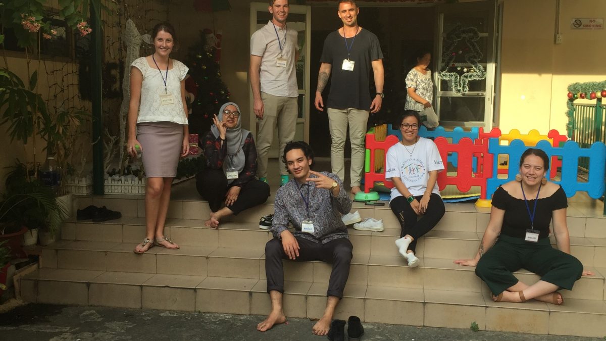 CRCC Asia Ho Chi Minh City interns sit on stairs during community outreach - interning in vietnam