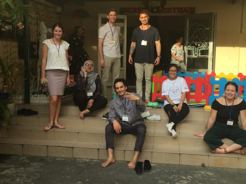 CRCC Asia Ho Chi Minh City interns sit on stairs during community outreach - interning in vietnam