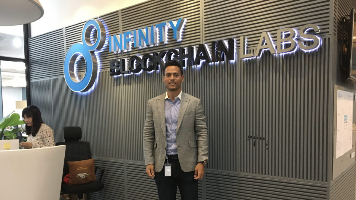 Carloz Marquez standing at reception desk of Infinity Blockchain Labs on his Blockchain Internship with CRCC Asia